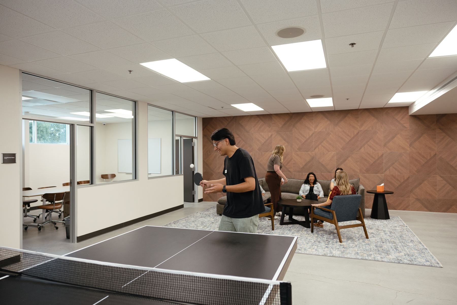 A student playing ping pong in the student lounge
