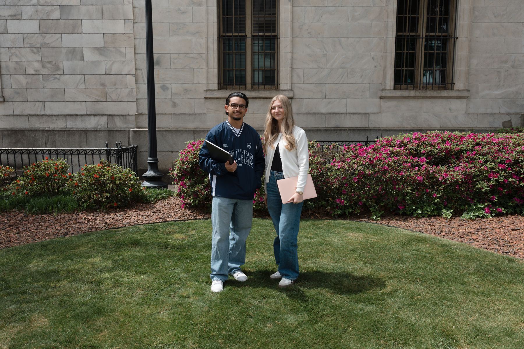 Two Free Chapel College students holding laptops outside